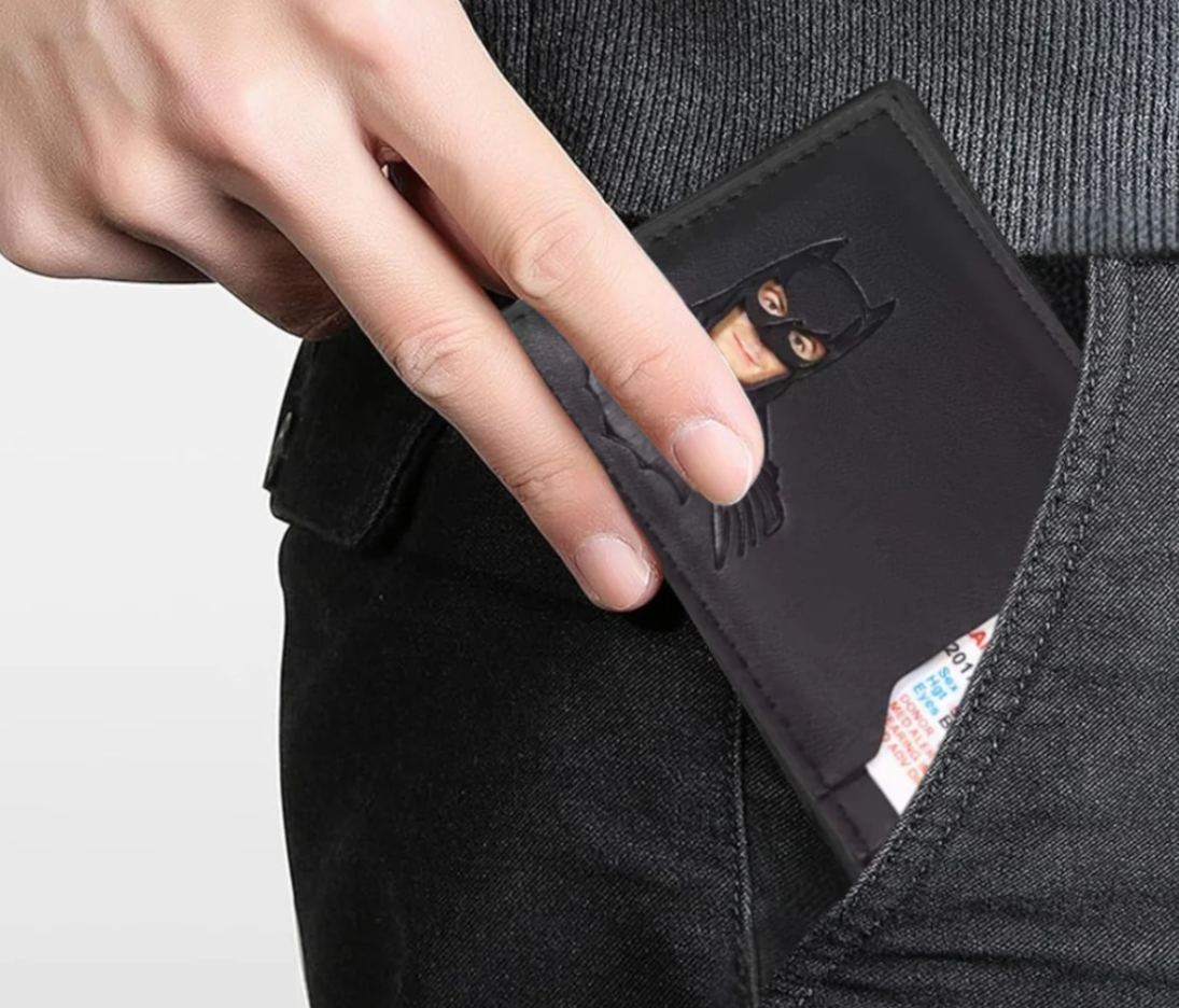 Dłoń wkładająca portfel DARKPOCKET z tłoczonym motywem do kieszeni jeansów